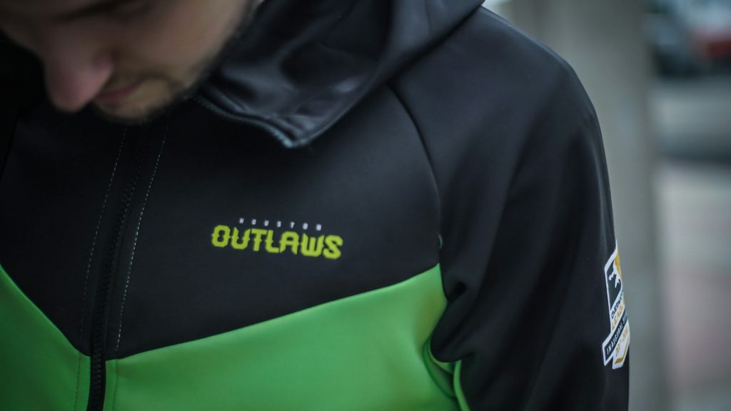 Ein professioneller esports-Spieler trägt eine Jacke mit dem Namen und den Sponsoren seines Teams